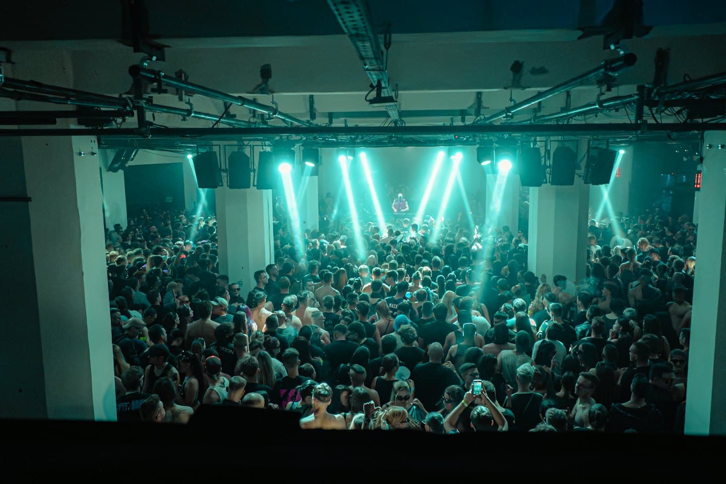 Eine große Menge tanzt gemeinsam auf einem Indoor-Musikkonzert.