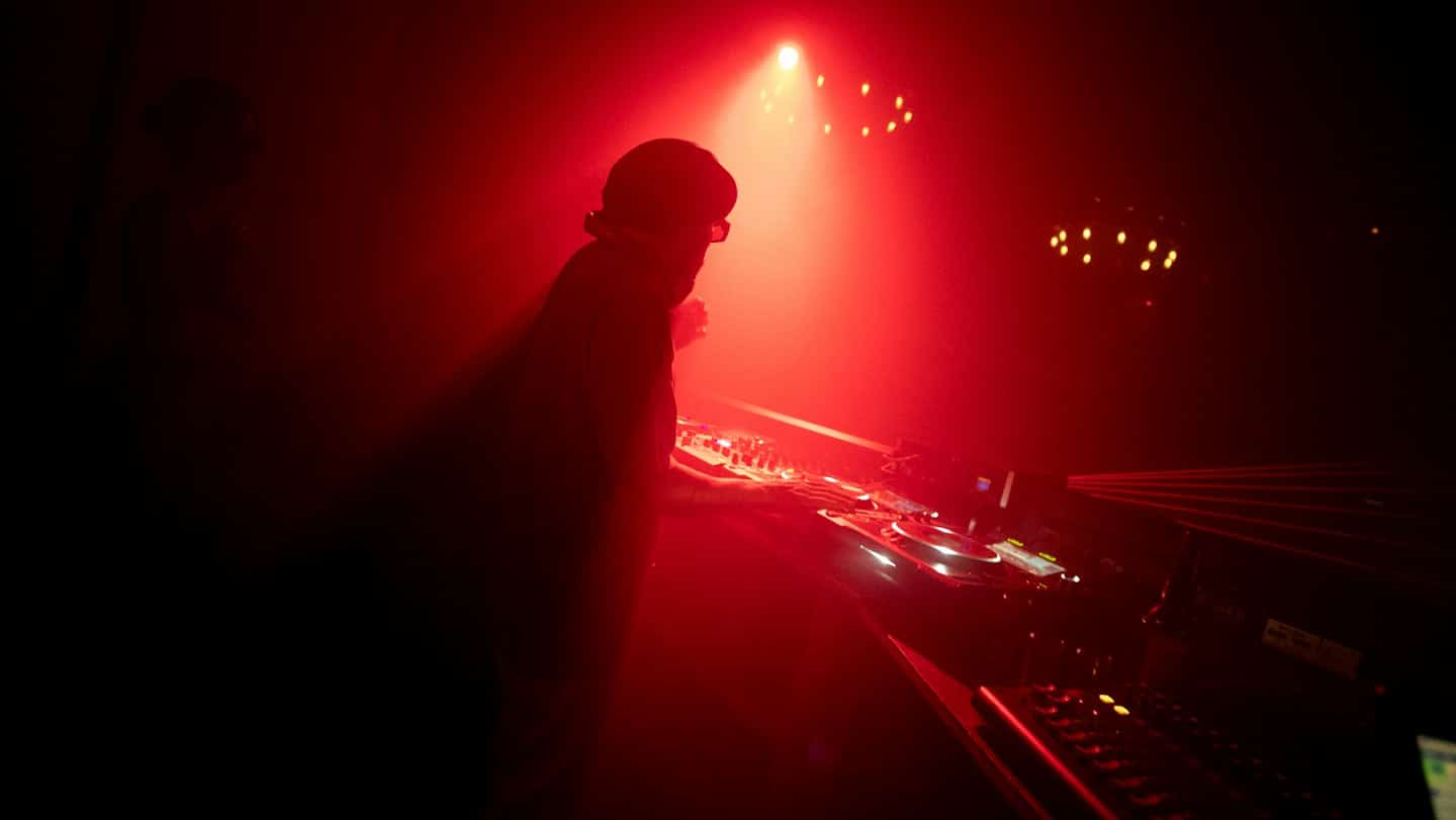 Silhouette eines DJs, der Musik in einem Club spielt.