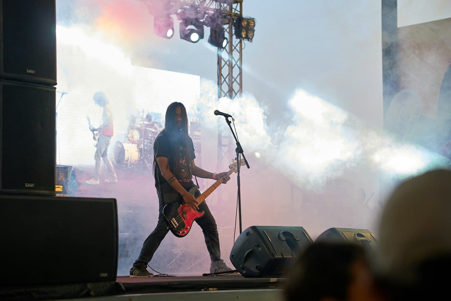 Bassist spielt live mit seiner Band auf der Bühne.